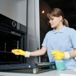 woman cleaning oven interior